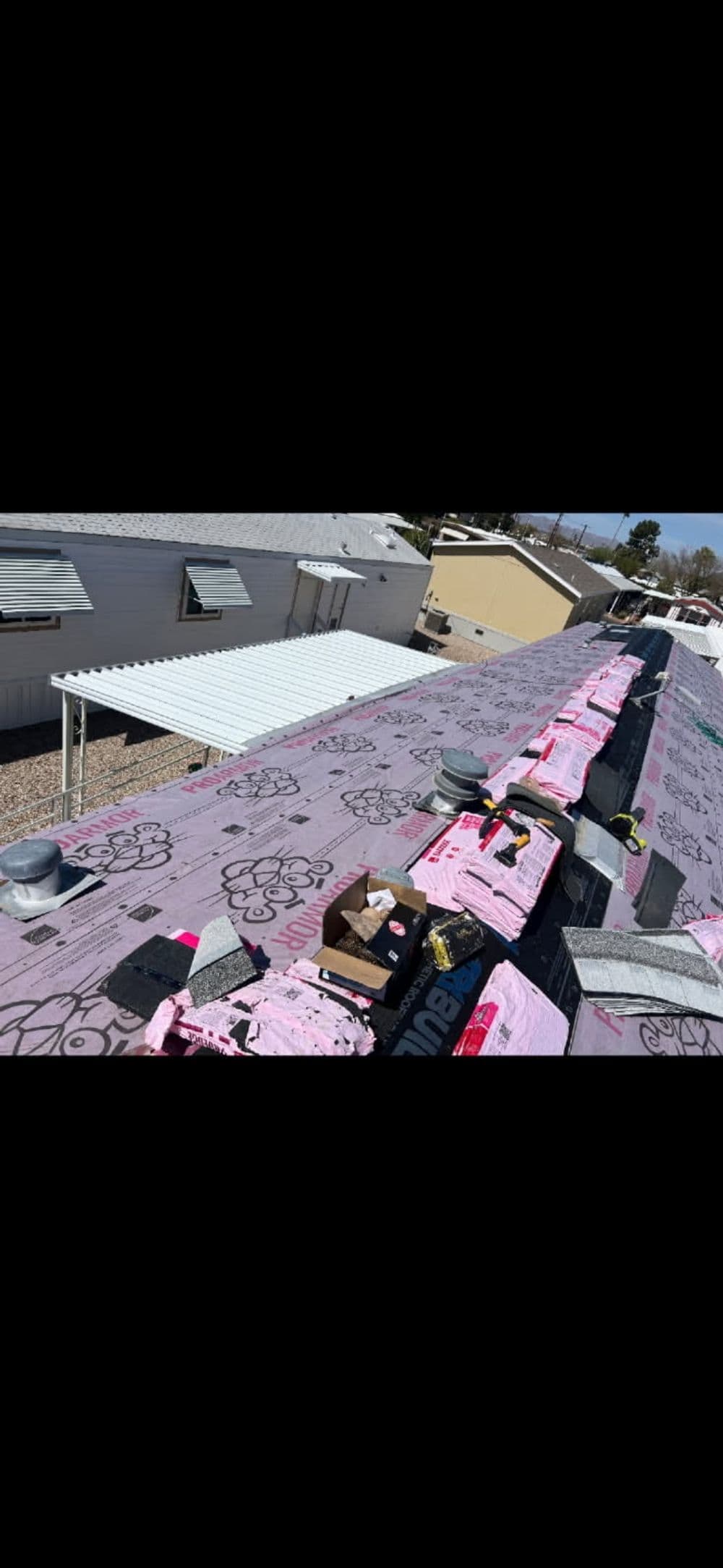 Aerial view of a residential roof with insulation and roofing materials in preparation for installation.