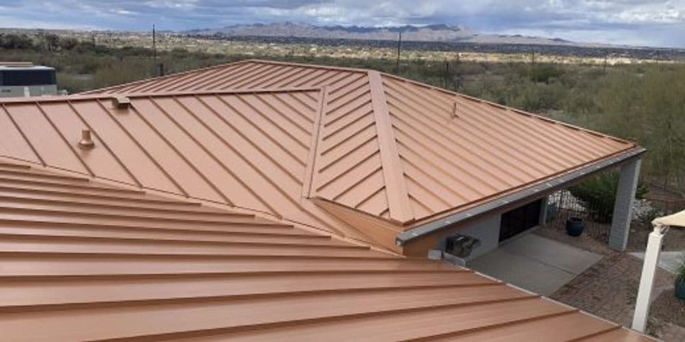 Metal roof with a copper finish and scenic mountain view in the background.